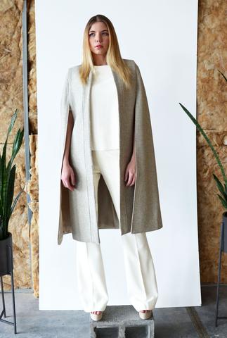 The Obi Cape is made of a beautiful sand melange melton wool and boasts of a clean tailored look. The cape has long openings for the arms and hangs beautifully.